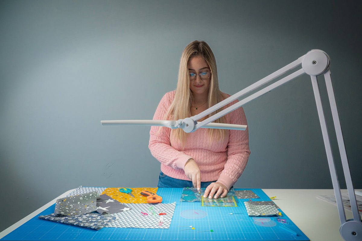 Daylight Lumi White LED task lamp illuminating a quilting workspace